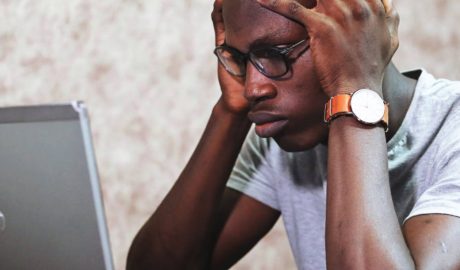 Man staring at computer screen looking confused