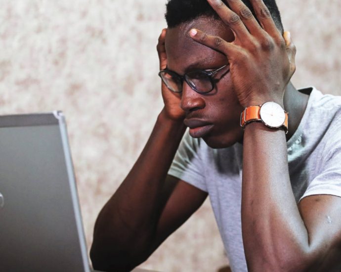 Man staring at computer screen looking confused