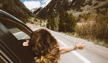 Woman with head out window of car