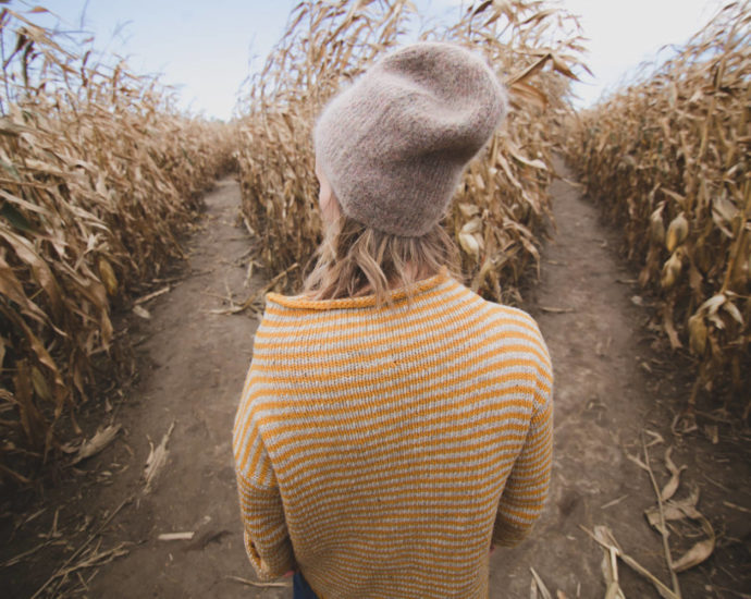 girl making decision between two paths in corn maze