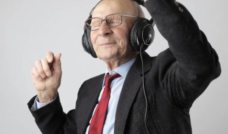 older man with headphones dancing and smiling