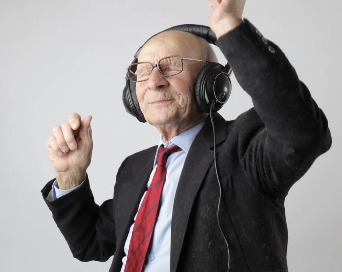 older man with headphones dancing and smiling