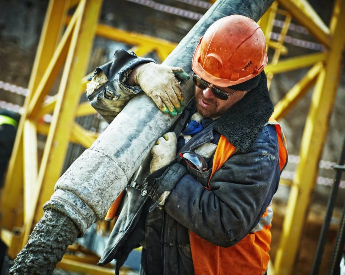 construction worker holding pipe