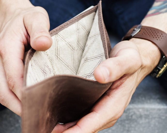 man holding open empty wallet