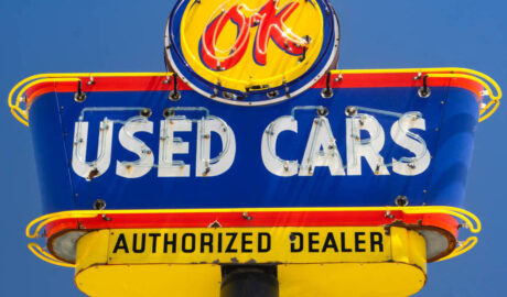 neon used cars sign in blue daylight