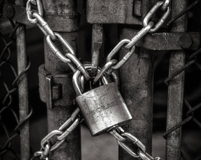 b/w closeup of chain locked to close gate