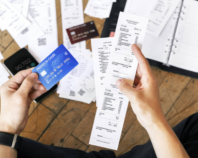 person holding credit card and receipts