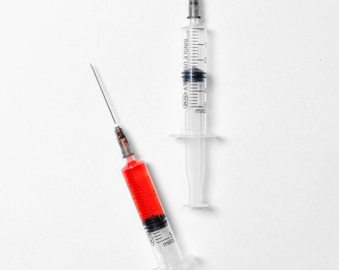 two syringes, one with red fluid