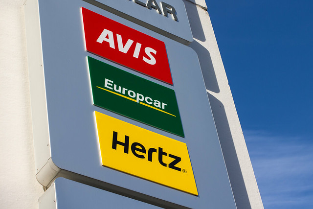 Rental car sign with Avis, Europcar and Hertz signage