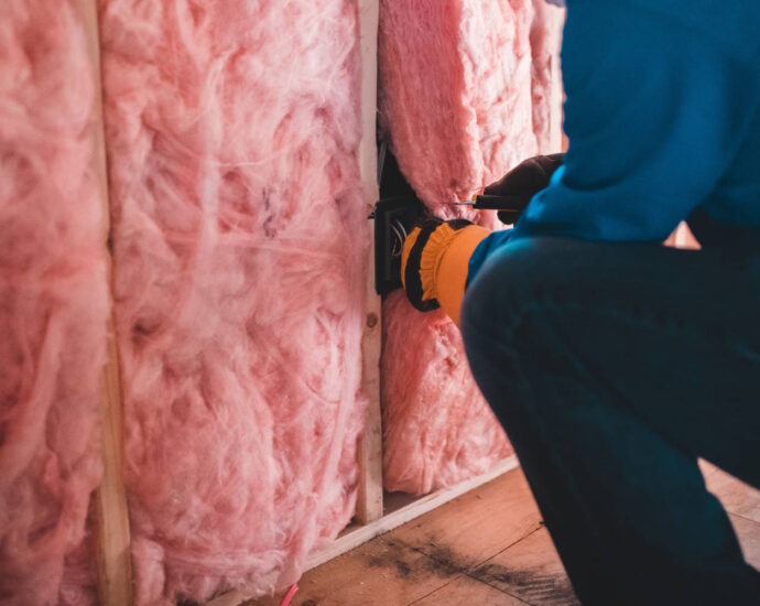 person installing pink insulation