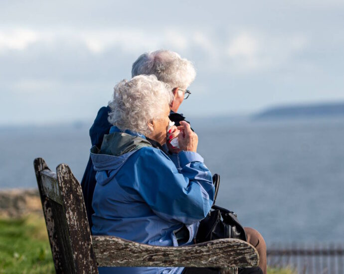 elderly couple on bench overlooking water