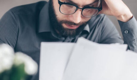 Stressed man looking over paperwork