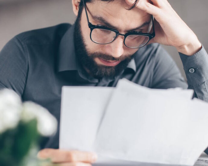 Stressed man looking over paperwork