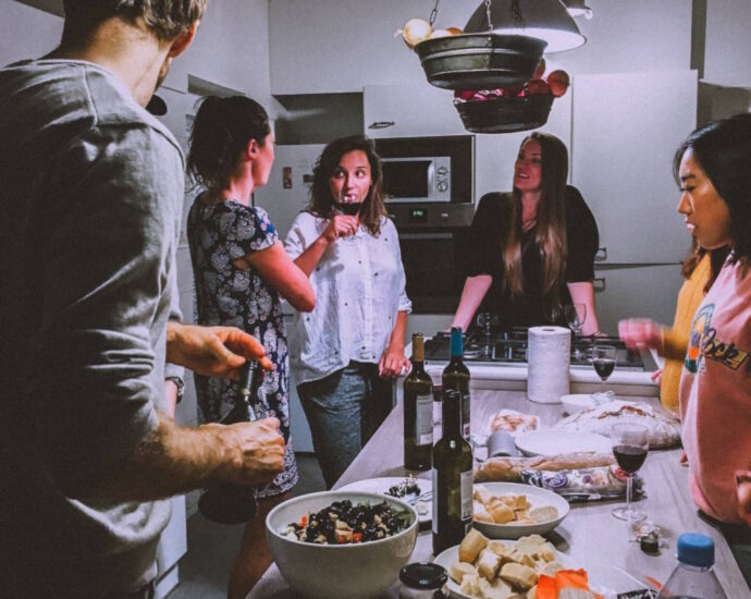 Group of friends talking around kitchen counter