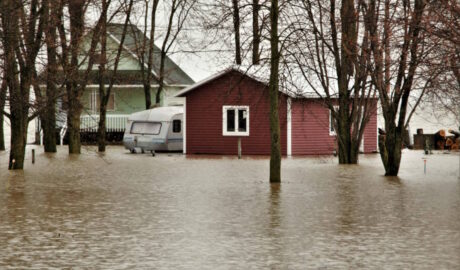 photo showing house and barn with several feet of water lapping up against them