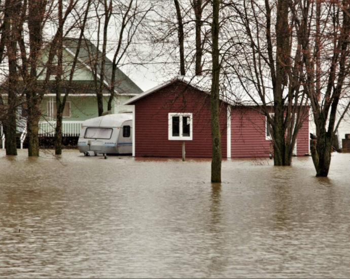 photo showing house and barn with several feet of water lapping up against them