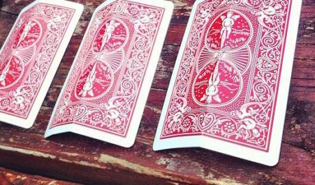 three folded cards turned down on a table a la three card monte