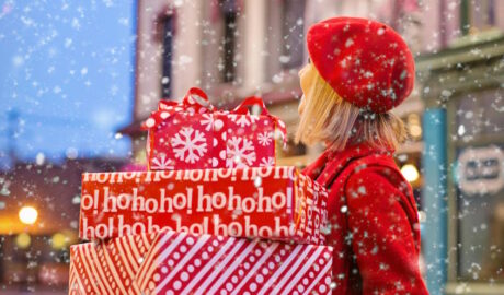 woman holding holiday presents in the snow