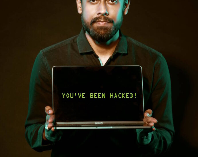 Man holding open laptop that reads "You've been hacked!"