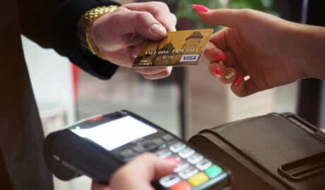 person handing over credit card to pay bill