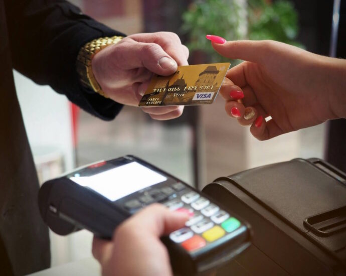 person handing over credit card to pay bill